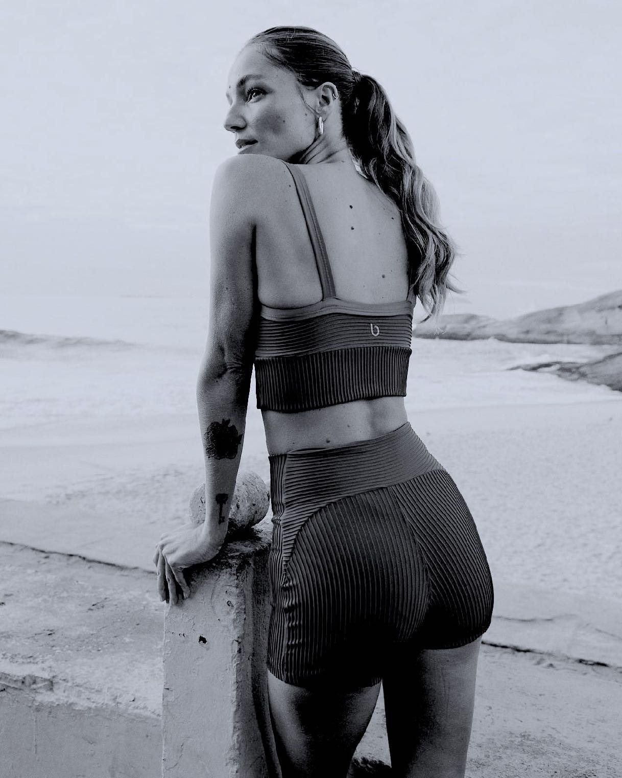 Modelo de costas usando top e legging canelada Bro, na orla do Rio de Janeiro